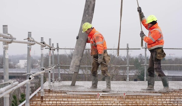 Deux ouvriers pose le plancher mixte bois béton HOBOA