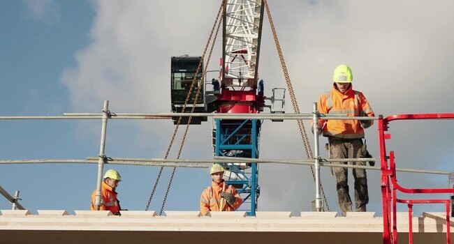 Trois ouvriers posent le plancher mixte bois béton HOBOA