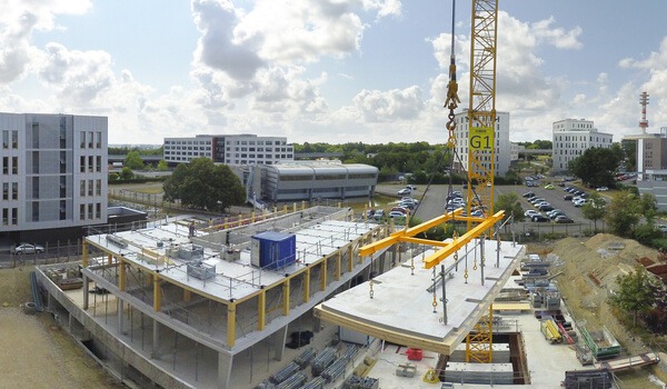 Une grue pose le plancher mixte bois béton HOBOA